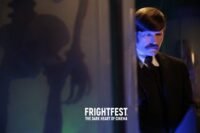 A man peaks out from behind a curtain with an exaggerated shadow of a skeleton on it. (A Blind Bargain)
