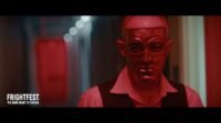 A man wearing a mask walks down a long hallway (Night of Violence)