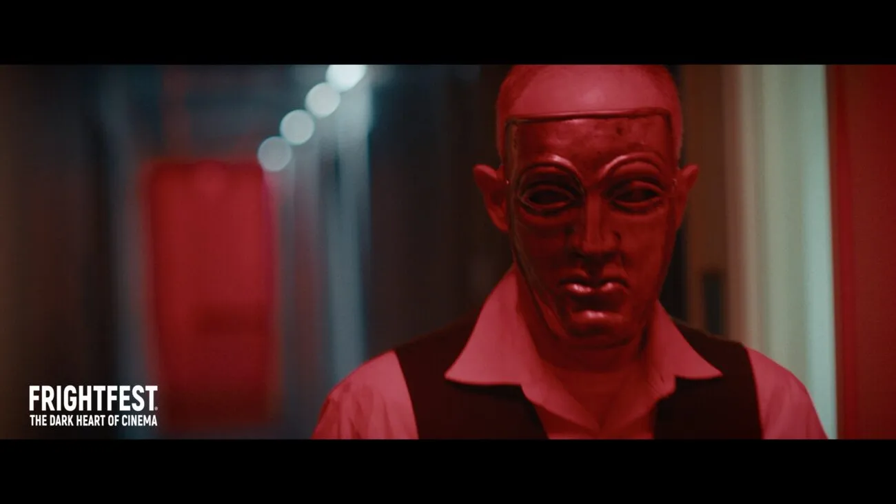 A man wearing a mask walks down a long hallway (Night of Violence)