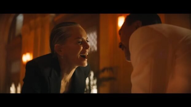 Lendina laughs as she stabs a man in the hand with a knife