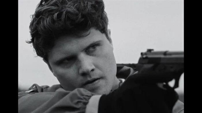 A young man holding a gun. (The School Duel)