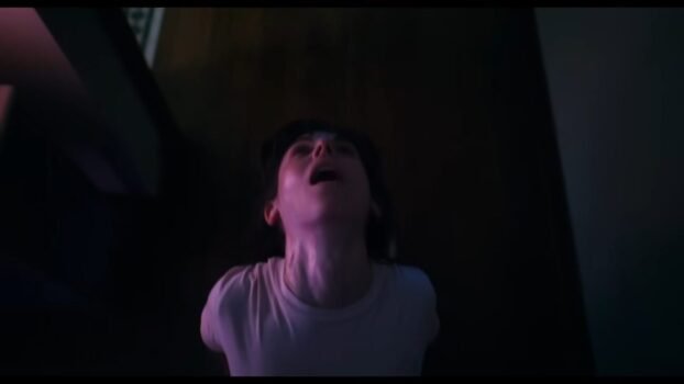 Millie's body contorts forward on the floor, with her head back
