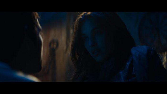A woman is seen talking to the profile of a man (Pig Hill)