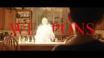 A woman stands in front of a explosion in a kitcher, while a child looks on from in front