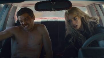 John is seen naked in the passenger seat while Edie is seen driving a car, both are leaning to their right as the car turns. (Eeenie Meanie)