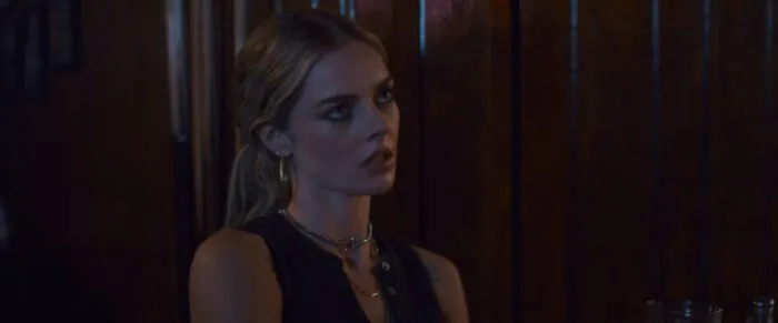 A woman stands in a bar rolling her eyes in annoyance