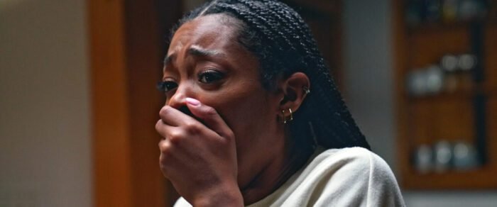 A worried young woman covers her mouth with her hand.