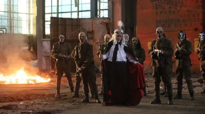 An ostentatious vampire leads a group of undeadin a warehouse where a fire has broken out.