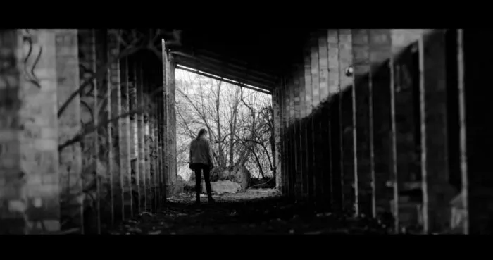 a person stands under a derelict structure.
