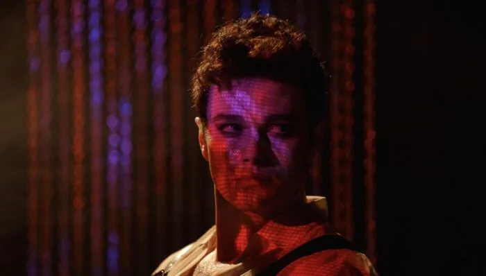 a man's face is obscured by some sort of colorful light display.