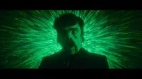 Winston (Peter Dinklage) is transformed into The Toxic Avenger in front of a psychedelic green background.