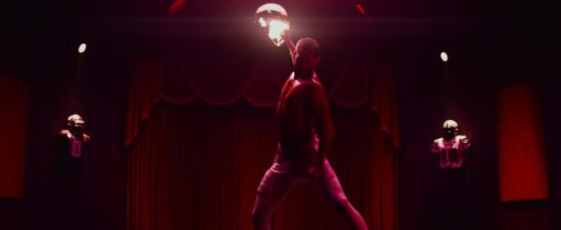 Cam (Tyriq Withers) pulls back a punch. He's in a room in all red