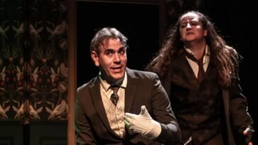 Jekyll sits while Hyde looms ominously over his left shoulder