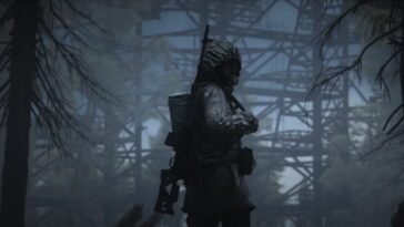 A man in a long coat and gasmask with a rifle over his shoulder walks through a dark forrest. He turns and looks at the camera