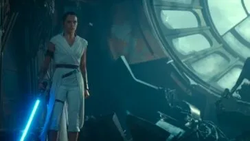 A Woman in a white robe stands with a blue light saber by her side, with a large window to her right