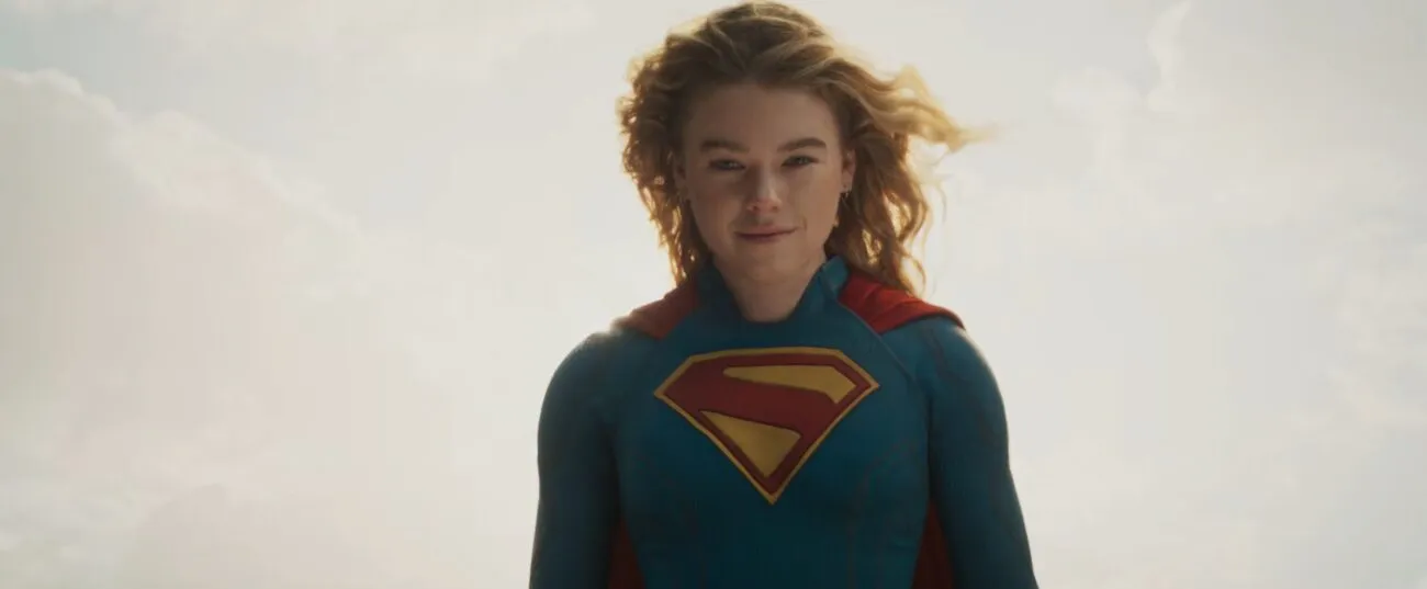 Milly Alcock as Supergirl floating in the sky, with a partial smile.
