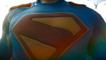 The crest of Superman takes up the majority of the shot, with the rest of the chest showing in the image. We do not see Superman's head - the image cuts off at the top just before then.